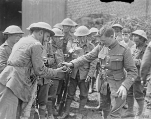 A Regimental Sergeant Major of 11th Battalion, Royal Scots hands out Mills bombs to a raiding party at Meteren. This raid was abandoned just when the party was ready to start owing to the leader being killed. Photograph taken on 12 July 1918.